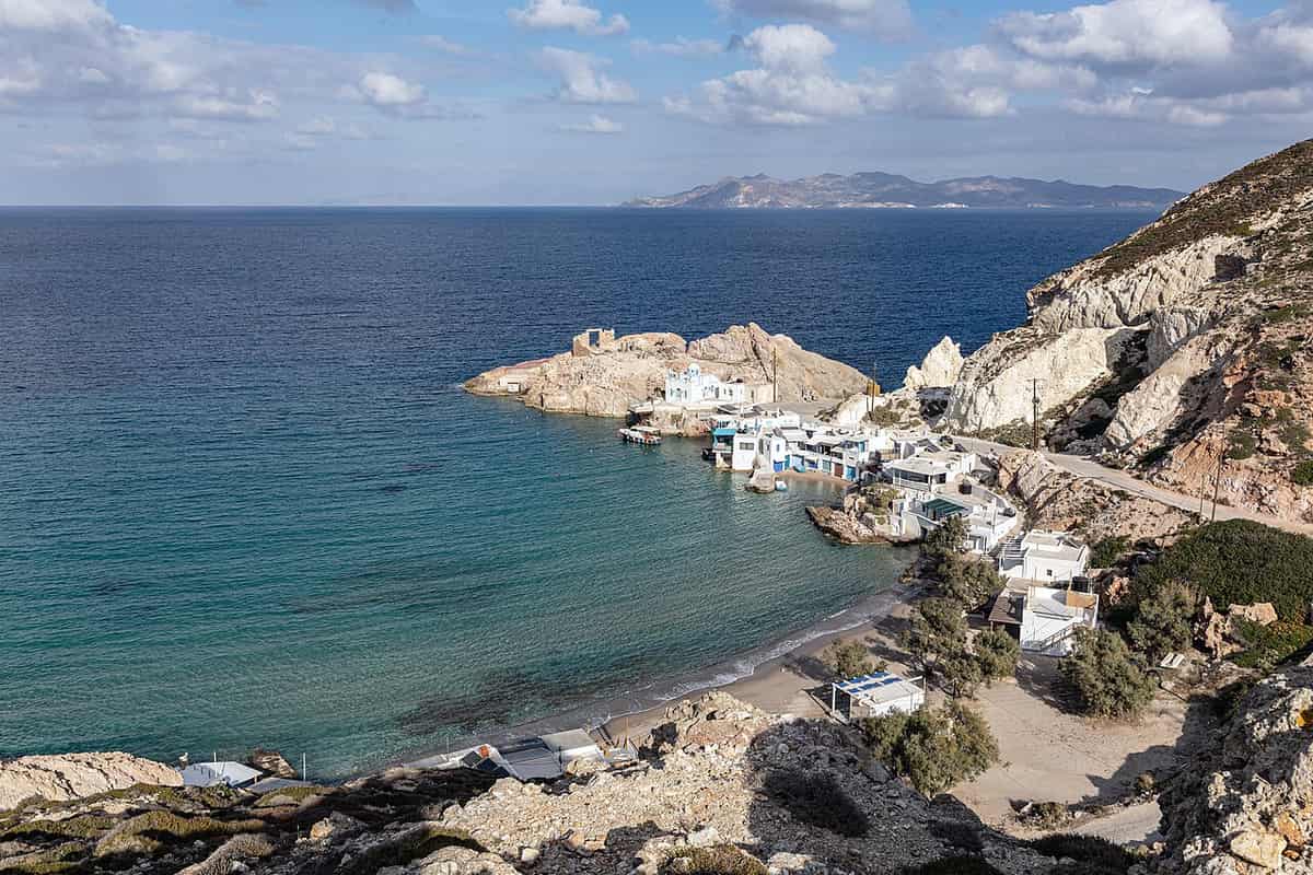 About Milos: the boathouses and white chapel of Firopotamos on a bay of the north coast of Milos