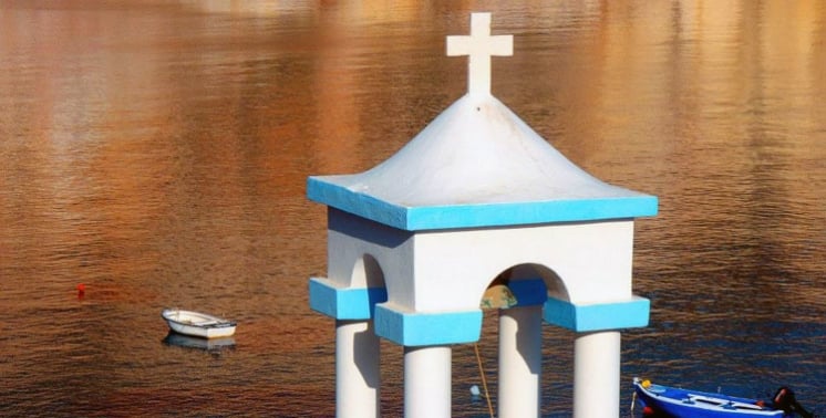 A small white bell tower by the water at Klima in Milos