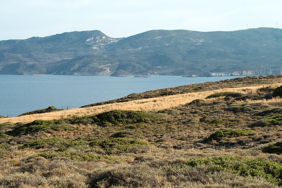 Achivadolimni beach area: the calm inner bay of Milos seen from the Nychia hill towards Rivari, with green hills beyond