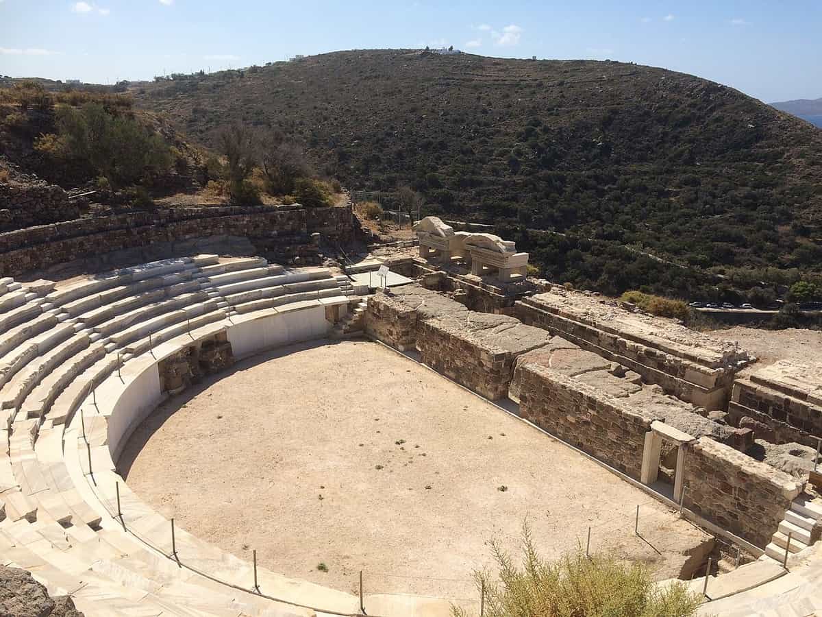 Ancient theatre of Milos: curved rows of white marble seats around the round floor of the orchestra