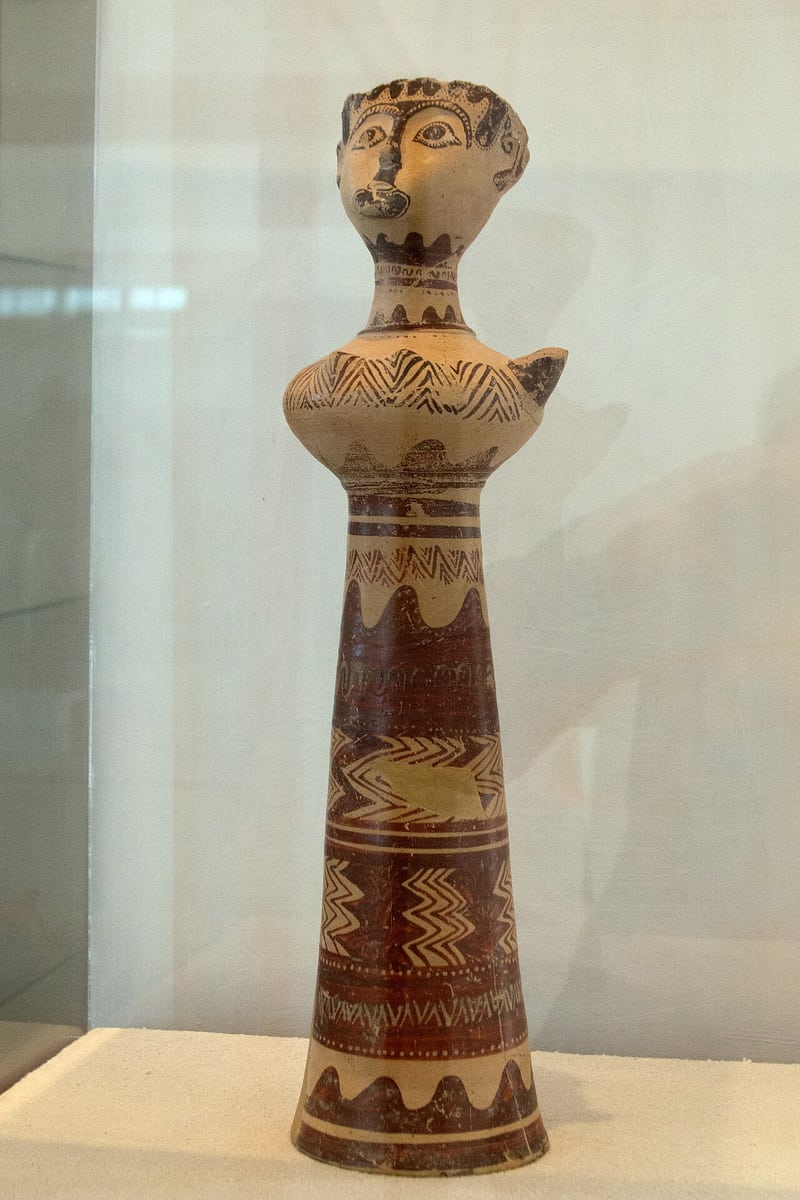 Archaeological Museum of Milos: the Lady of Phylakopi, a painted clay figure of a woman with large eyes and zigzag bands on a tall bell-shaped body