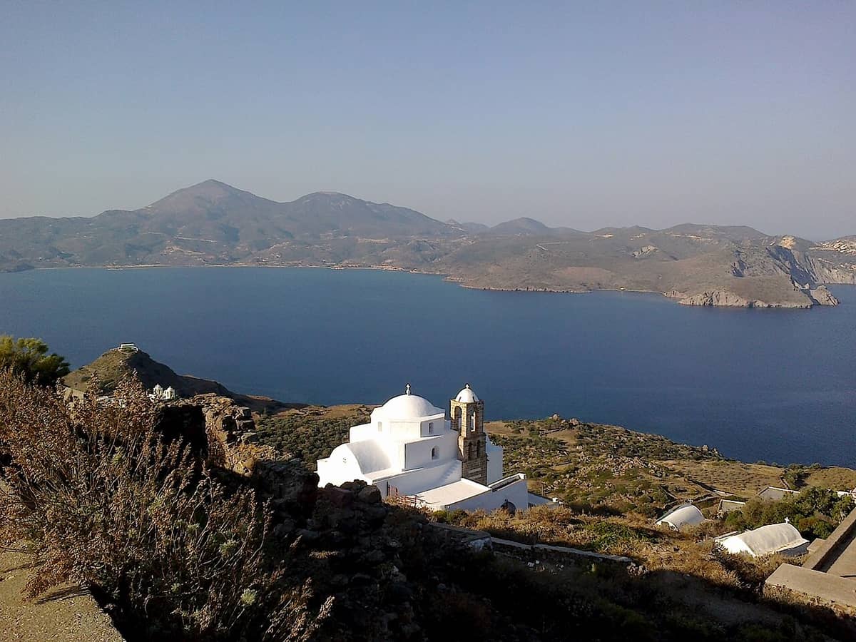 Best sunset in Milos: the castle hill church and the wide bay of Milos in soft late-day light