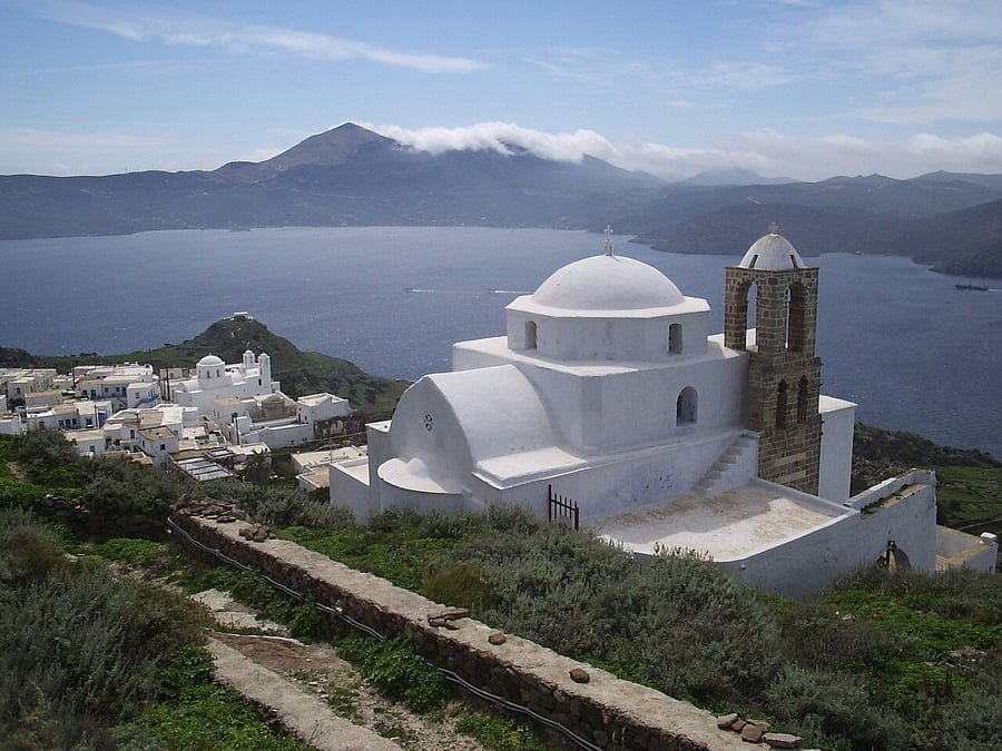 Best sunset in Milos: the white church of Panagia Thalassitra on the castle hill above Plaka, with the bay below