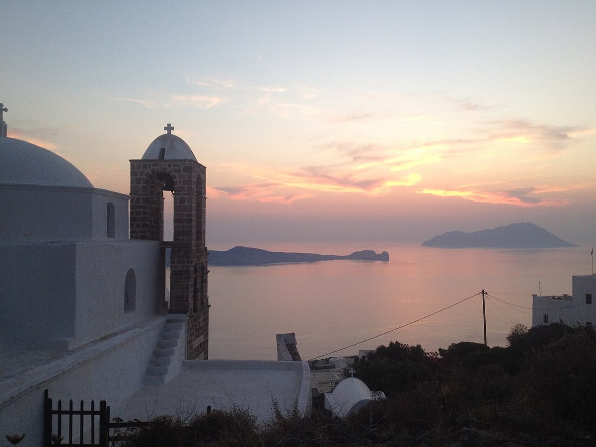 Coffee and drinks in Milos: sunset over the sea and Antimilos seen from a church terrace in Plaka