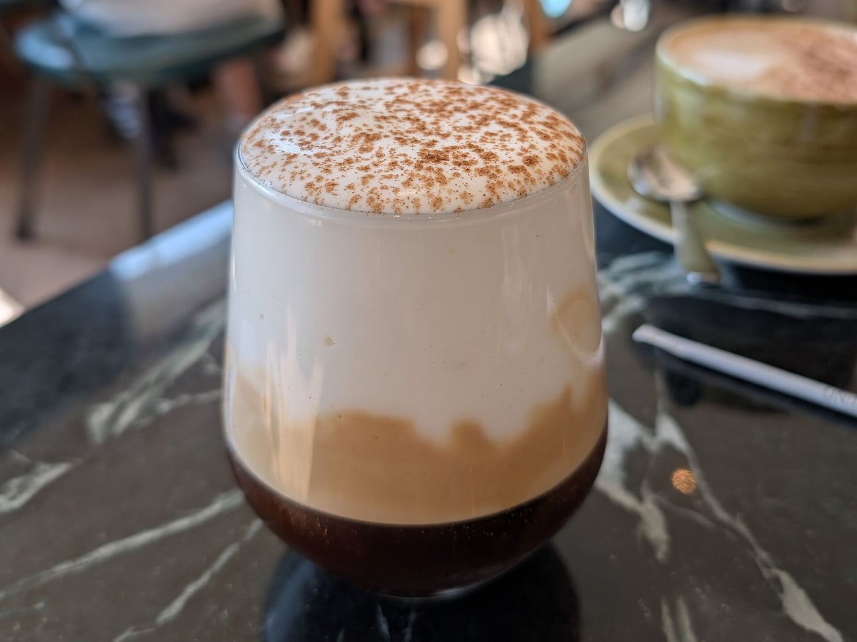 Coffee and drinks in Provatas: a freddo cappuccino with cold milk foam and cinnamon in a glass on a café table on Milos