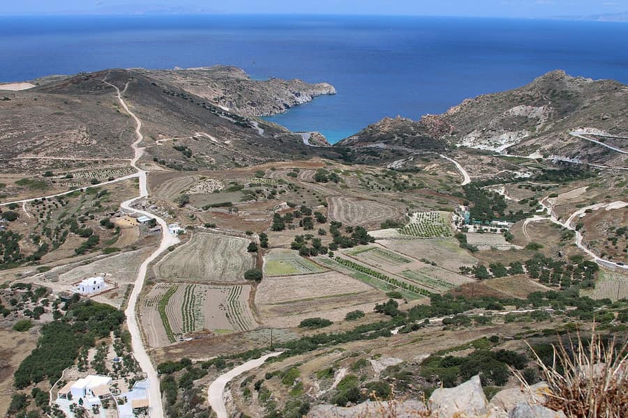 Milos e-bike tour: winding country roads running down from Plaka through fields and terraces to a blue bay