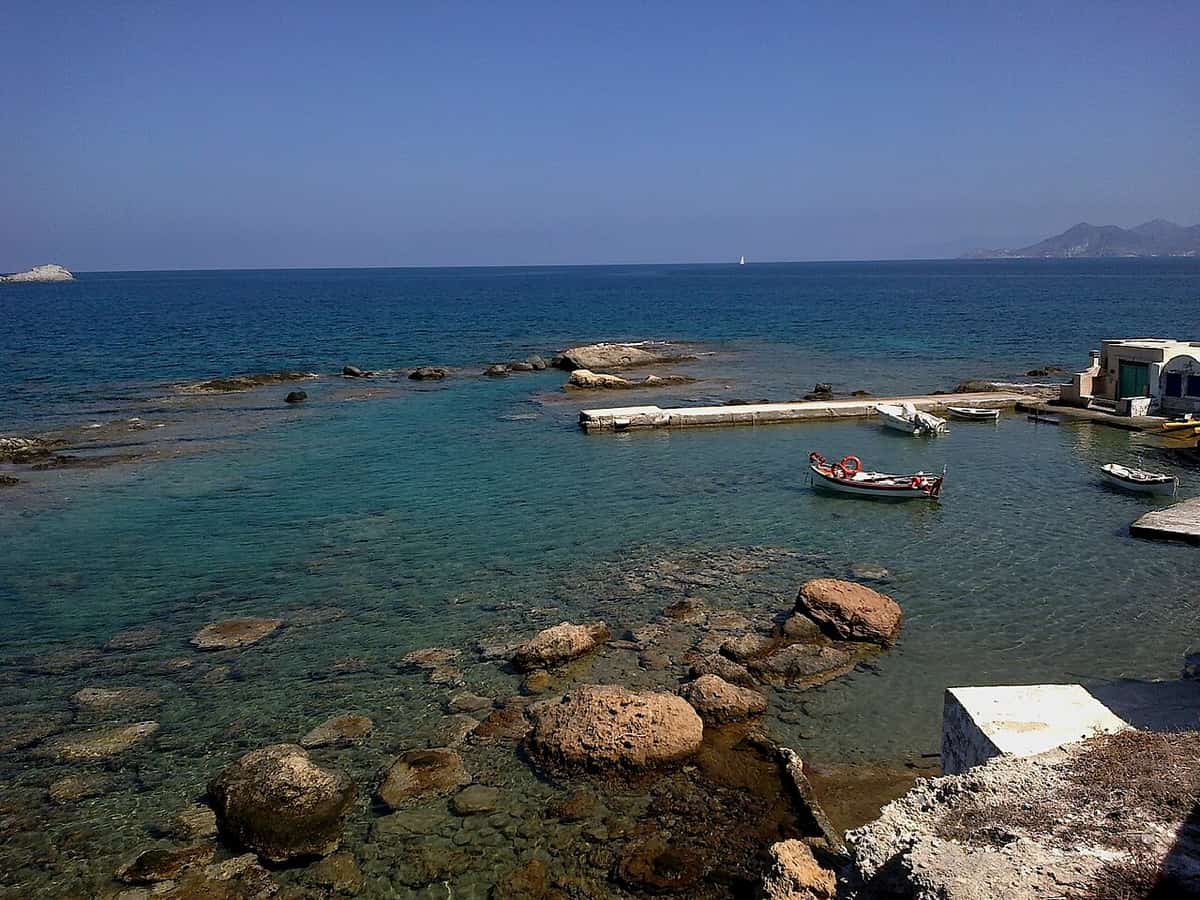 Food and drink in Milos: a traditional fishing boat moored in the clear water of the small harbour of Mandrakia