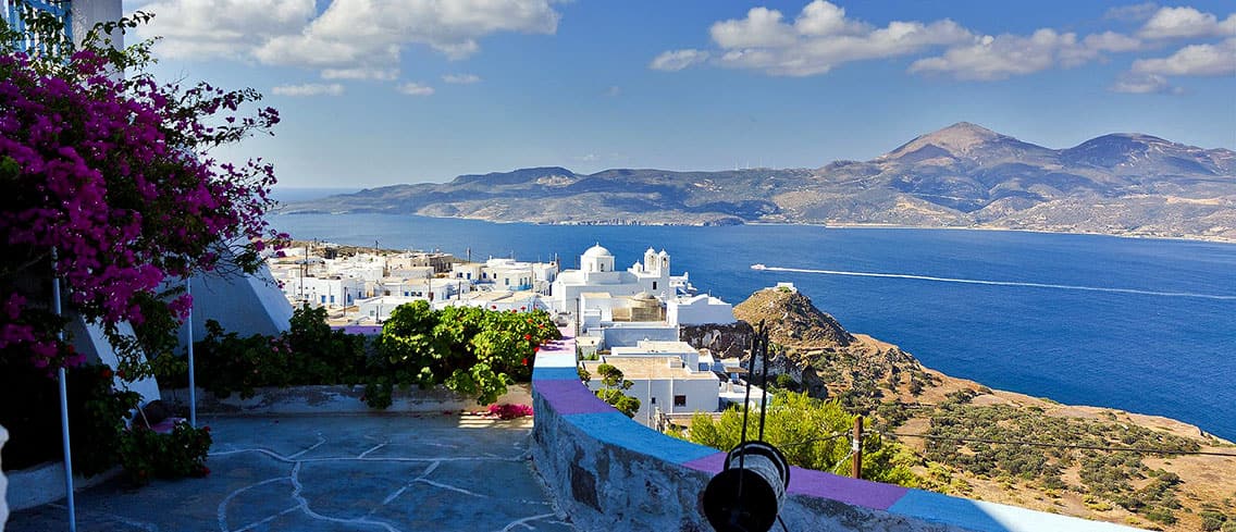 View over the bay of Milos from a terrace in Plaka with bougainvillea