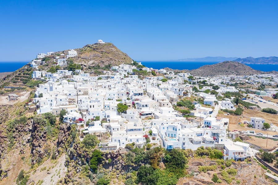 Milos itinerary: the white houses of Plaka spread over the hill, with the castle hill above and the sea behind