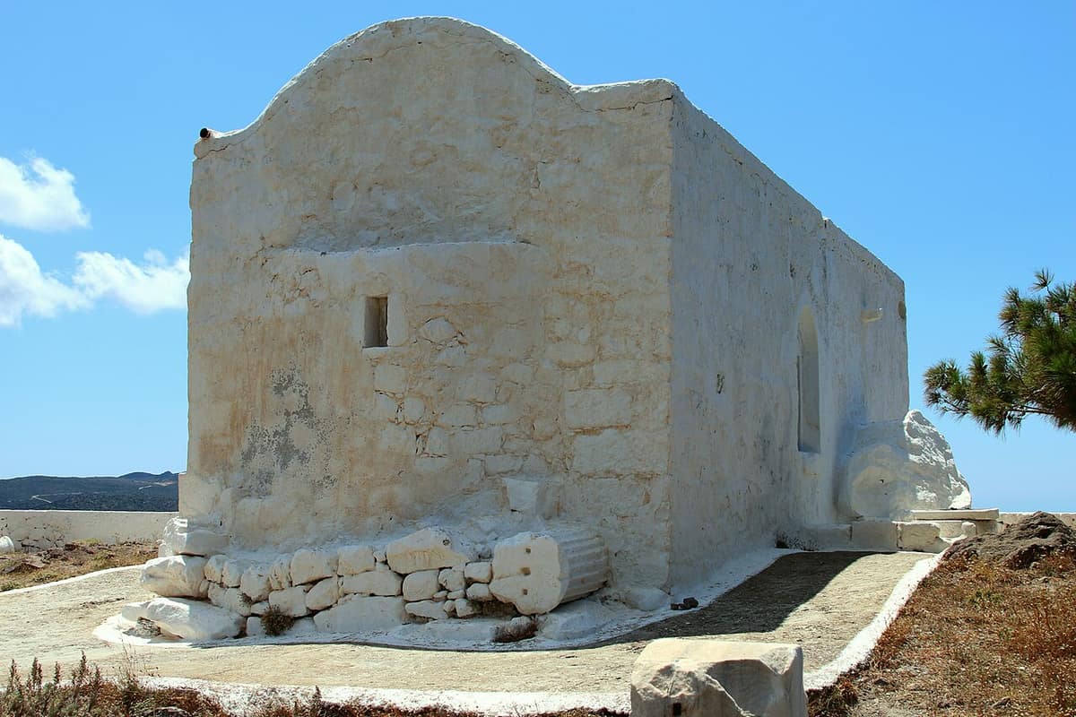 Milos jeep tour: the whitewashed church of Profitis Ilias standing on open stony ground under a blue sky