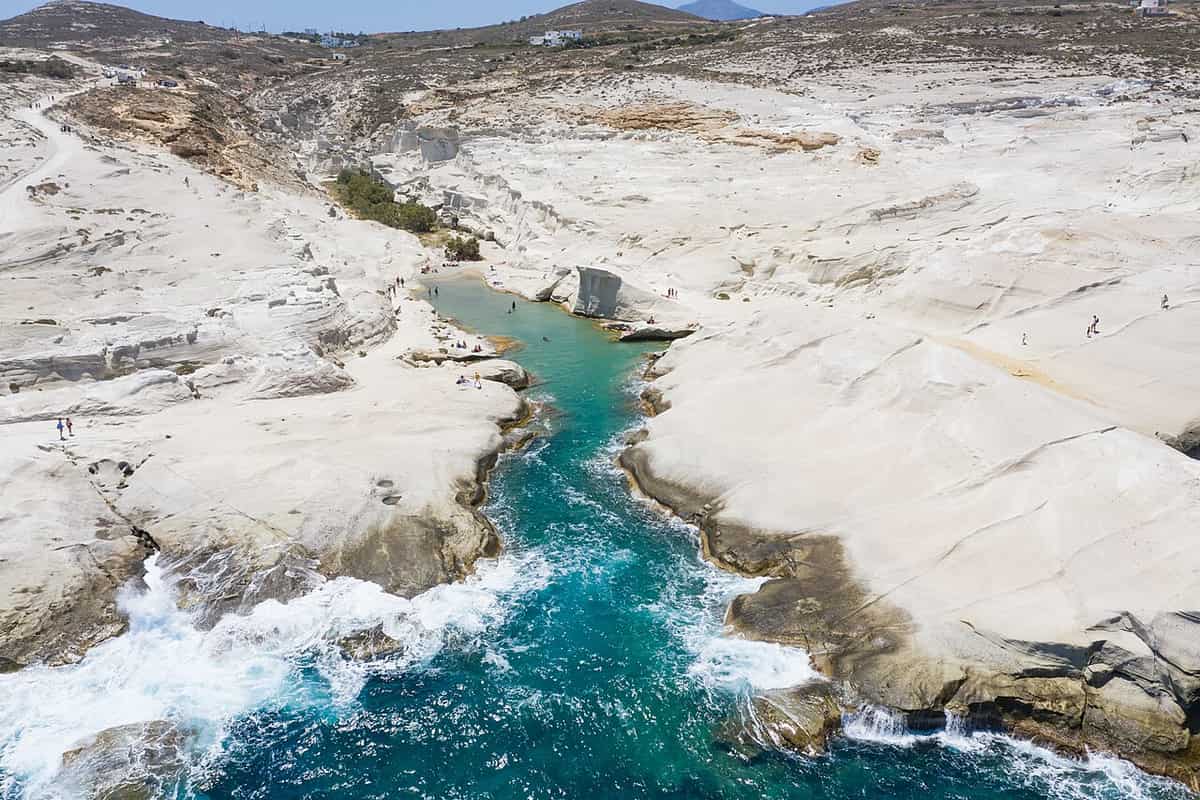 Kayak Sarakiniko: a channel of turquoise water running between the white volcanic rocks of Sarakiniko, seen from the sea side