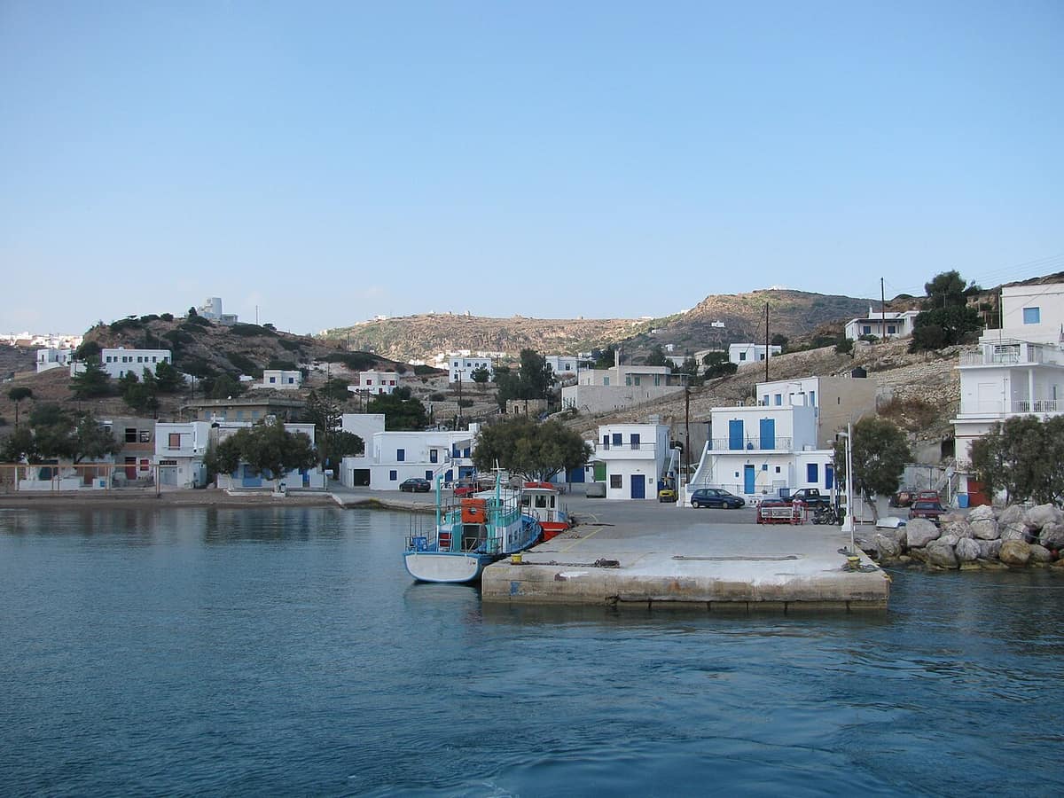 Kimolos boat trip: small boats at the quay of Psathi, the harbour of Kimolos, below white houses on the hillside