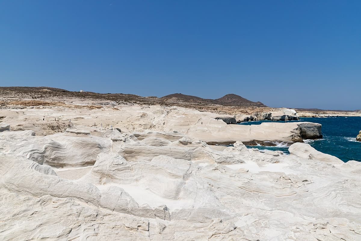 Milos geo walks: layered white volcanic rock shaped by wind and sea on the north coast of Milos