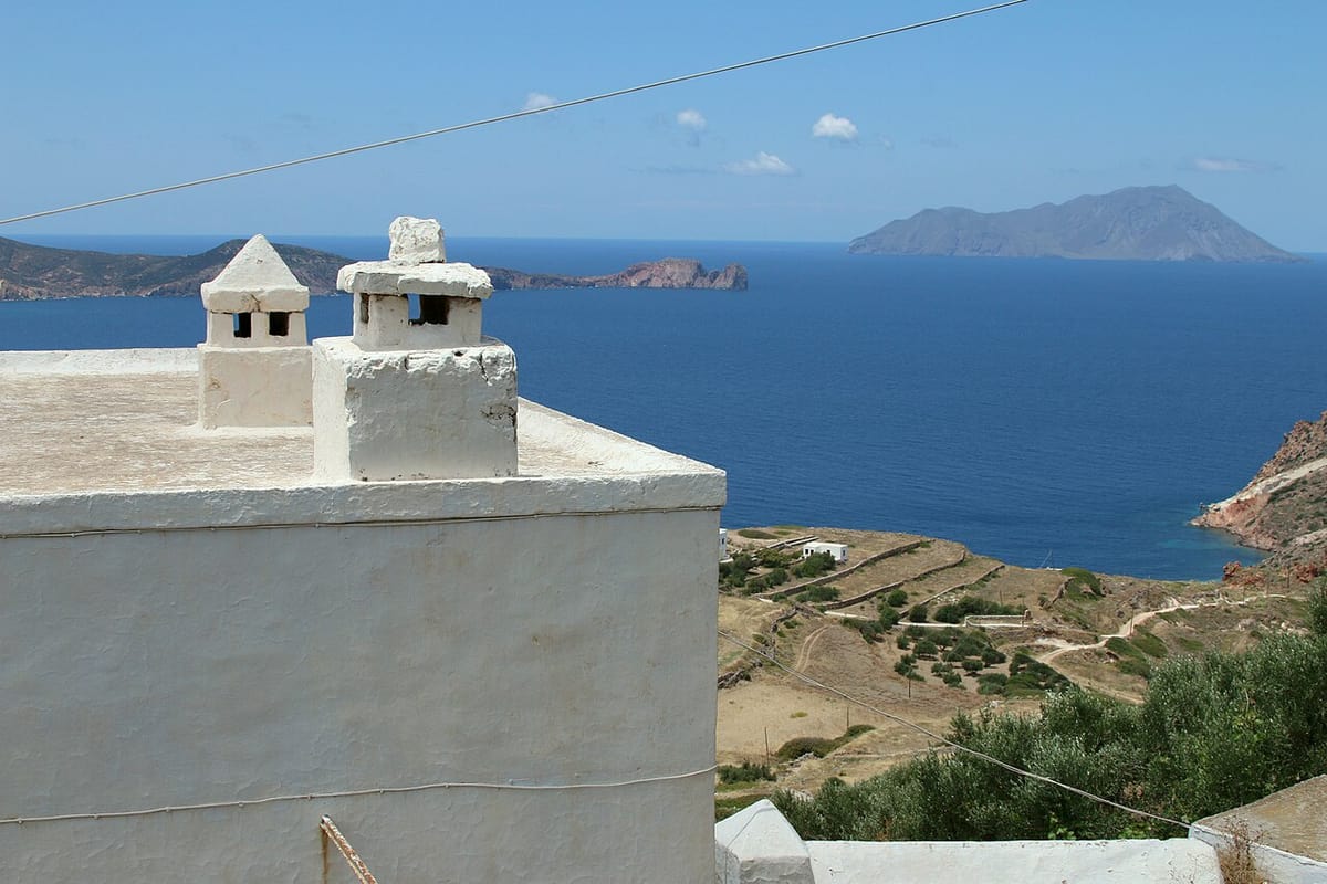 Milos information: view from the Kastro of Plaka over terraced fields and the sea towards the island of Antimilos