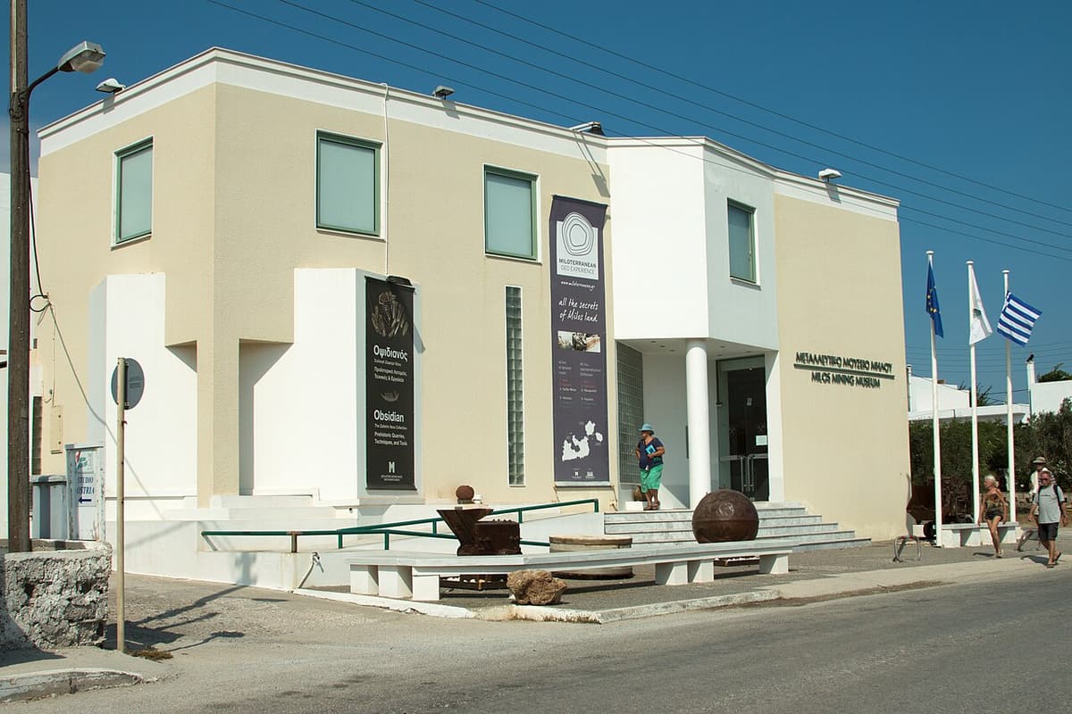 Mineral museum of Milos: the Milos Mining Museum building in Adamantas, with old mining equipment by the entrance steps