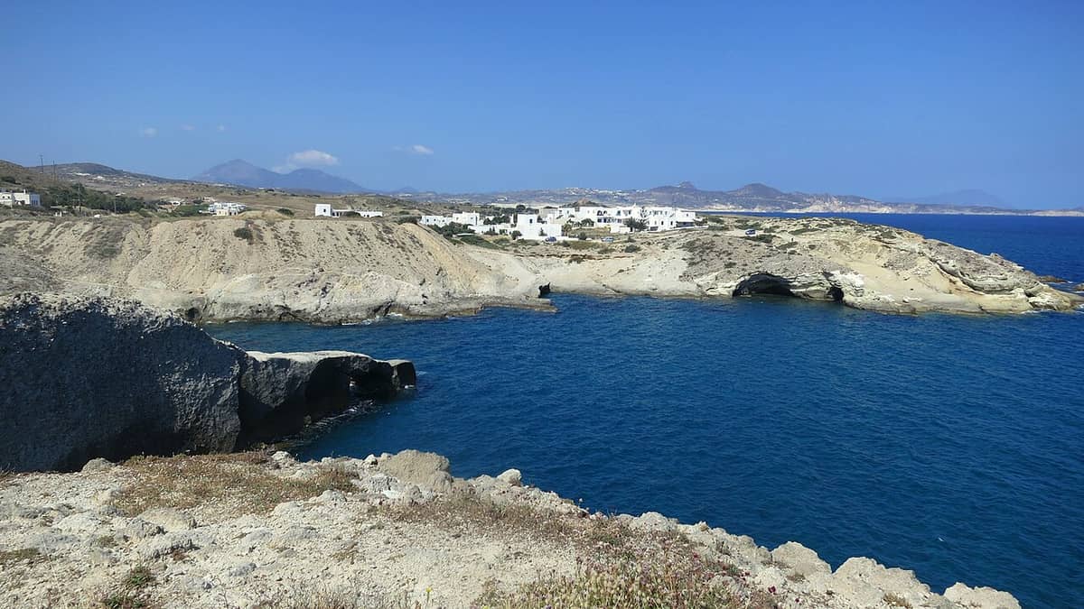 Niriides Studios Milos: the rocky coast at Papafragas near Pachena, with sea caves, white houses and deep blue water