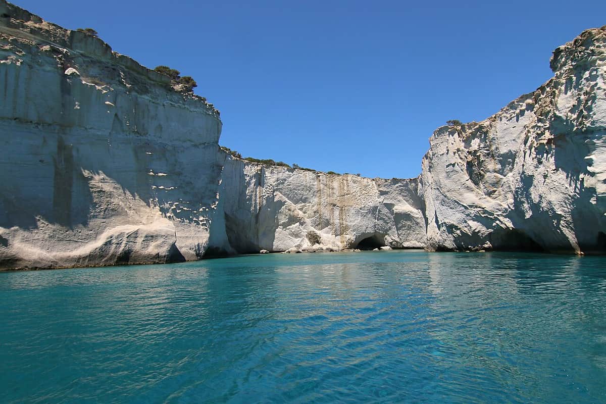 One day cruises from Adamas: the turquoise bay of Kleftiko between tall white volcanic cliffs and sea caves
