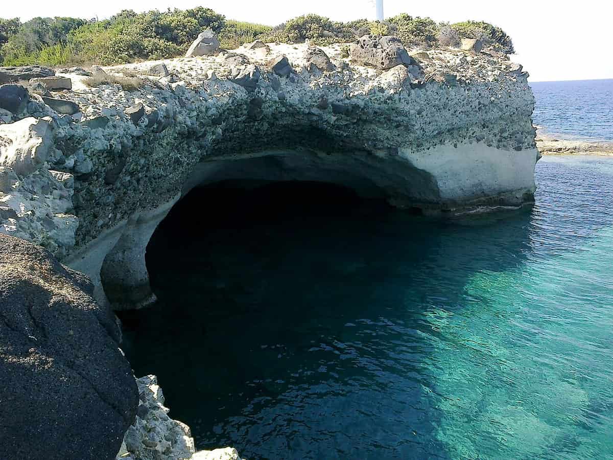 Ostria Vento Rooms Milos: a sea cave in the white rock of the Agios Nikolaos cape at Pollonia, above clear turquoise water