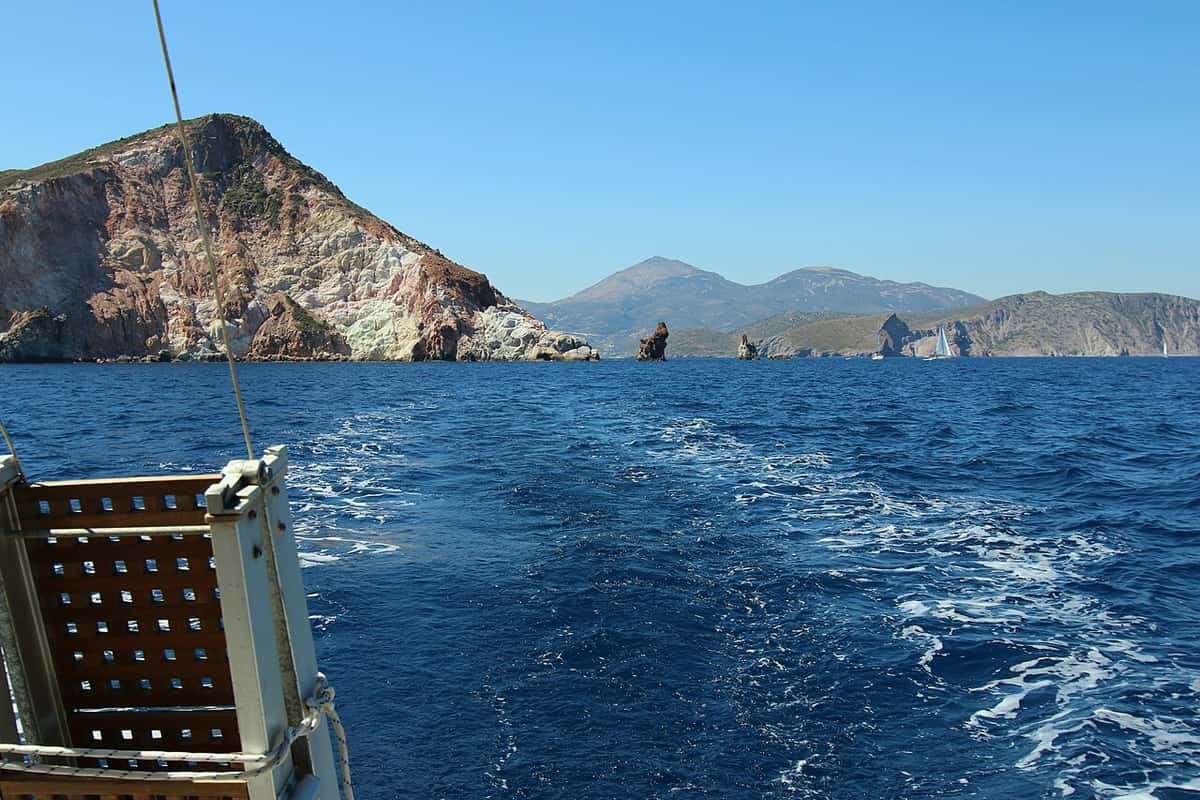 Plathiena beach coast: the tall Arkoudes rocks and cliffs rising from the deep blue sea near Plathiena on Milos