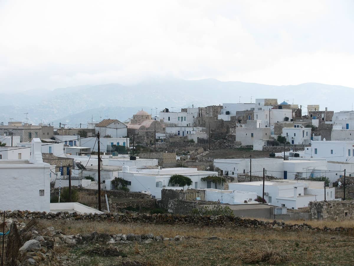 Rent a car Kimolos: the white houses of Chorio, the main village of Kimolos, spread over the low hill above the fields