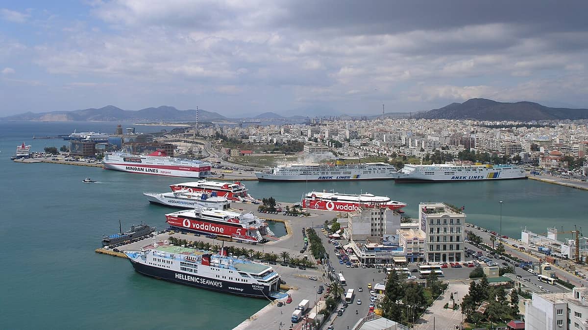 Rent a car Piraeus: the port of Piraeus seen from above, with ferries at the quays and the city spreading to the hills of Attica