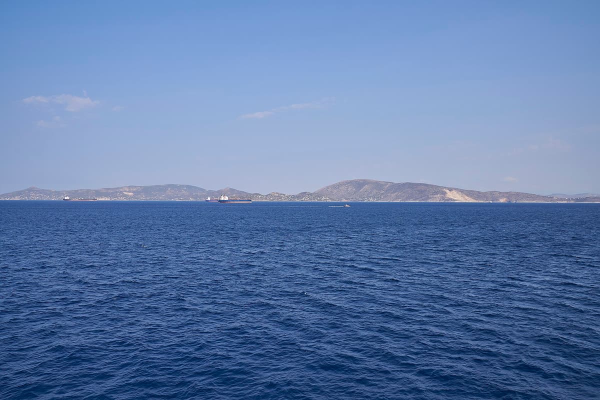 Rent a car Salamina: the long low hills of Salamis island across the calm blue water of the Saronic Gulf