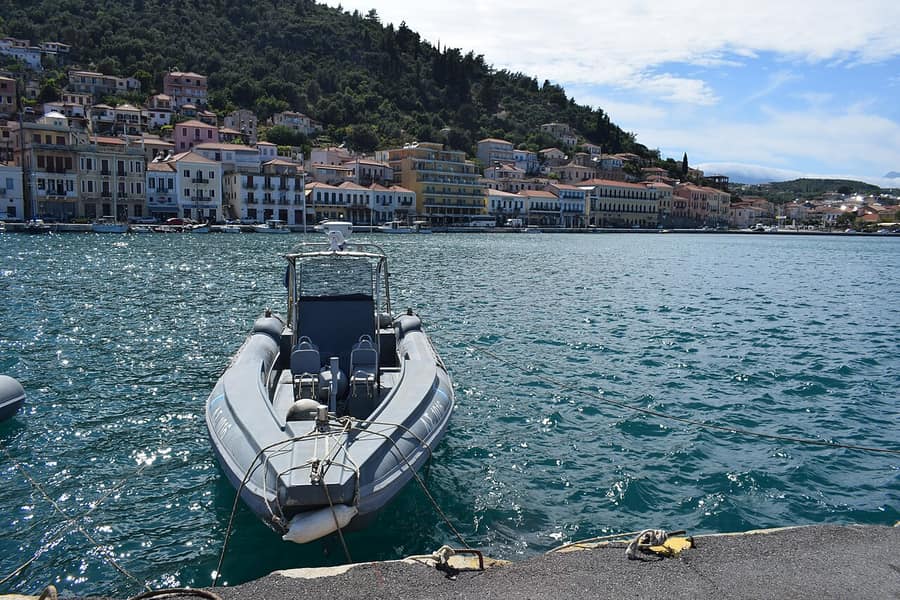 Milos speedboat tour: a grey RIB with a centre console moored in a calm Greek harbour