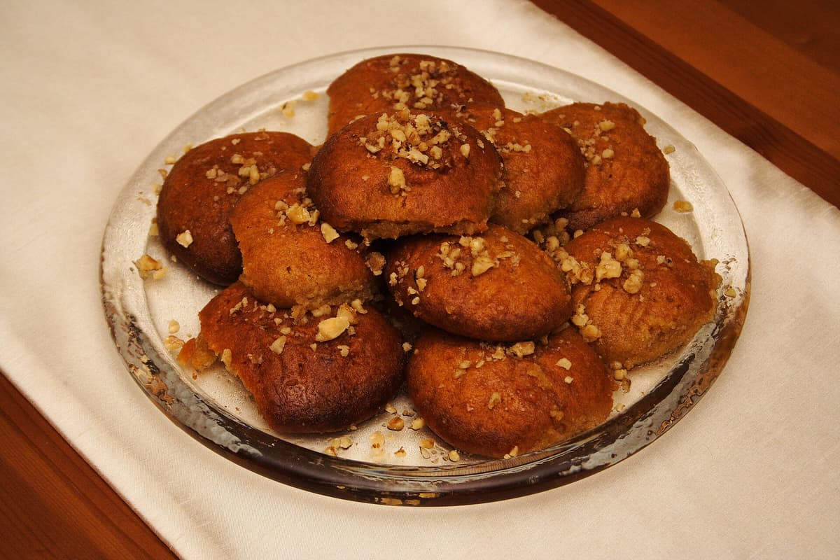 Sweets in Plaka Milos: melomakarona, Greek Christmas honey cookies topped with chopped walnuts, on a glass plate