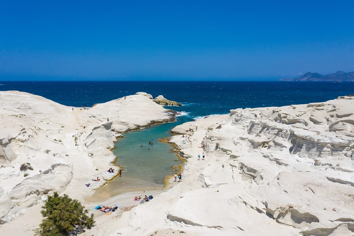 Milos taxi to Sarakiniko: aerial view of the white volcanic rocks and turquoise inlet on the north coast of Milos