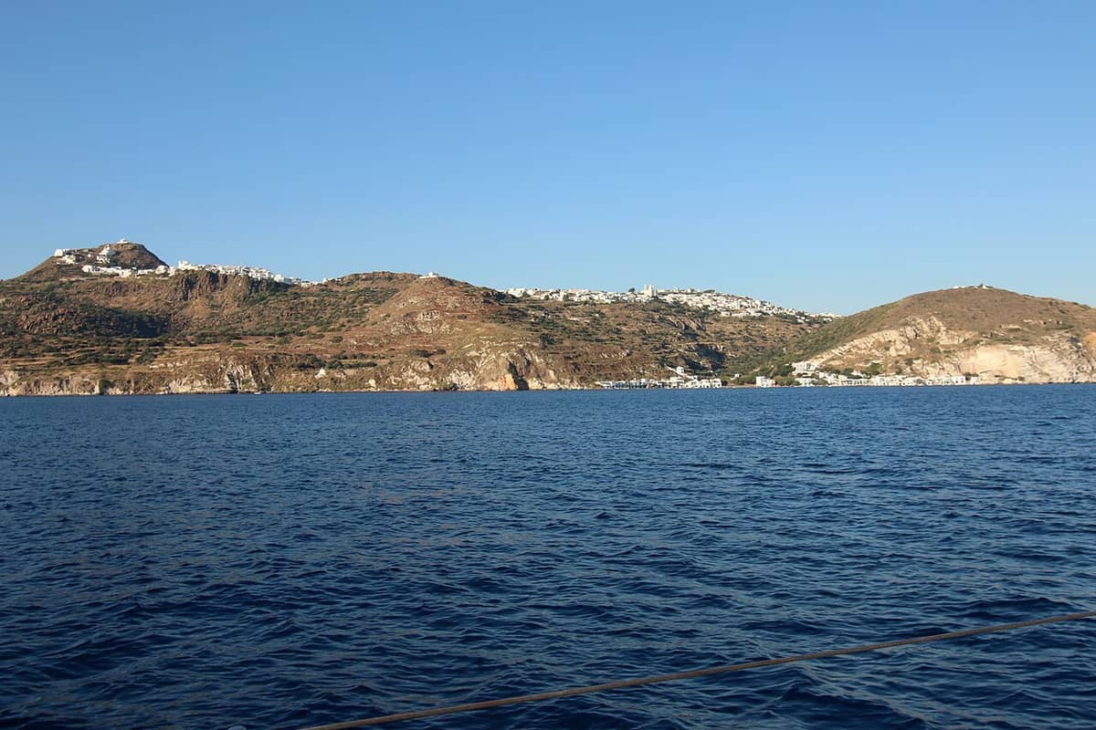 Tripiti Milos: the ridge of Plaka and Tripiti with white houses on top, seen from the sea above the coast of Klima