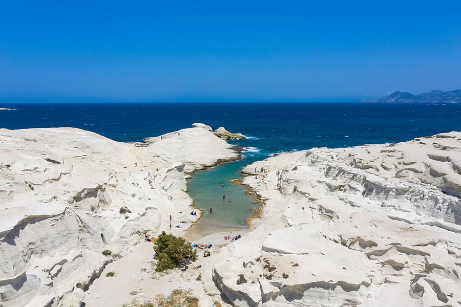 Milos with kids: the white volcanic rock of Sarakiniko around a narrow inlet with a small sandy beach