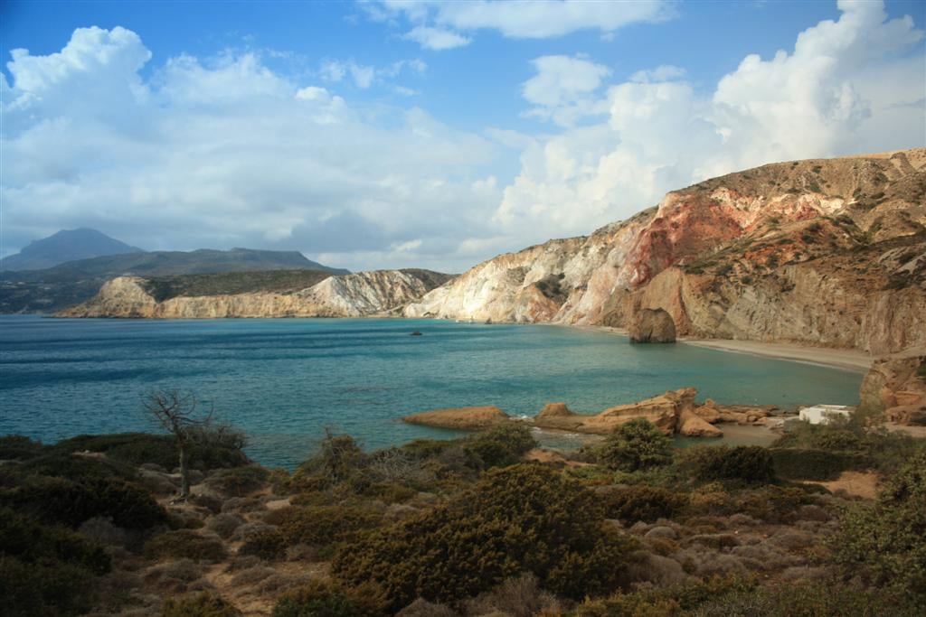 Φυρίπλακα: κόλπος με τιρκουάζ νερά κάτω από ψηλά κόκκινα, κίτρινα και λευκά ηφαιστειακά βράχια