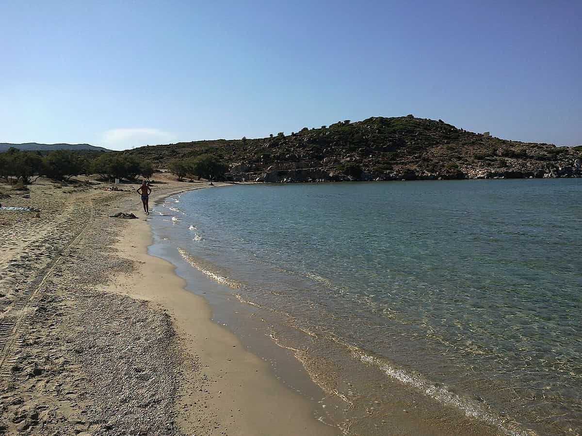 Κάμπινγκ Μήλος: η δυτική άκρη της παραλίας της Αχιβαδολίμνης με ήρεμο νερό και χαμηλούς λόφους