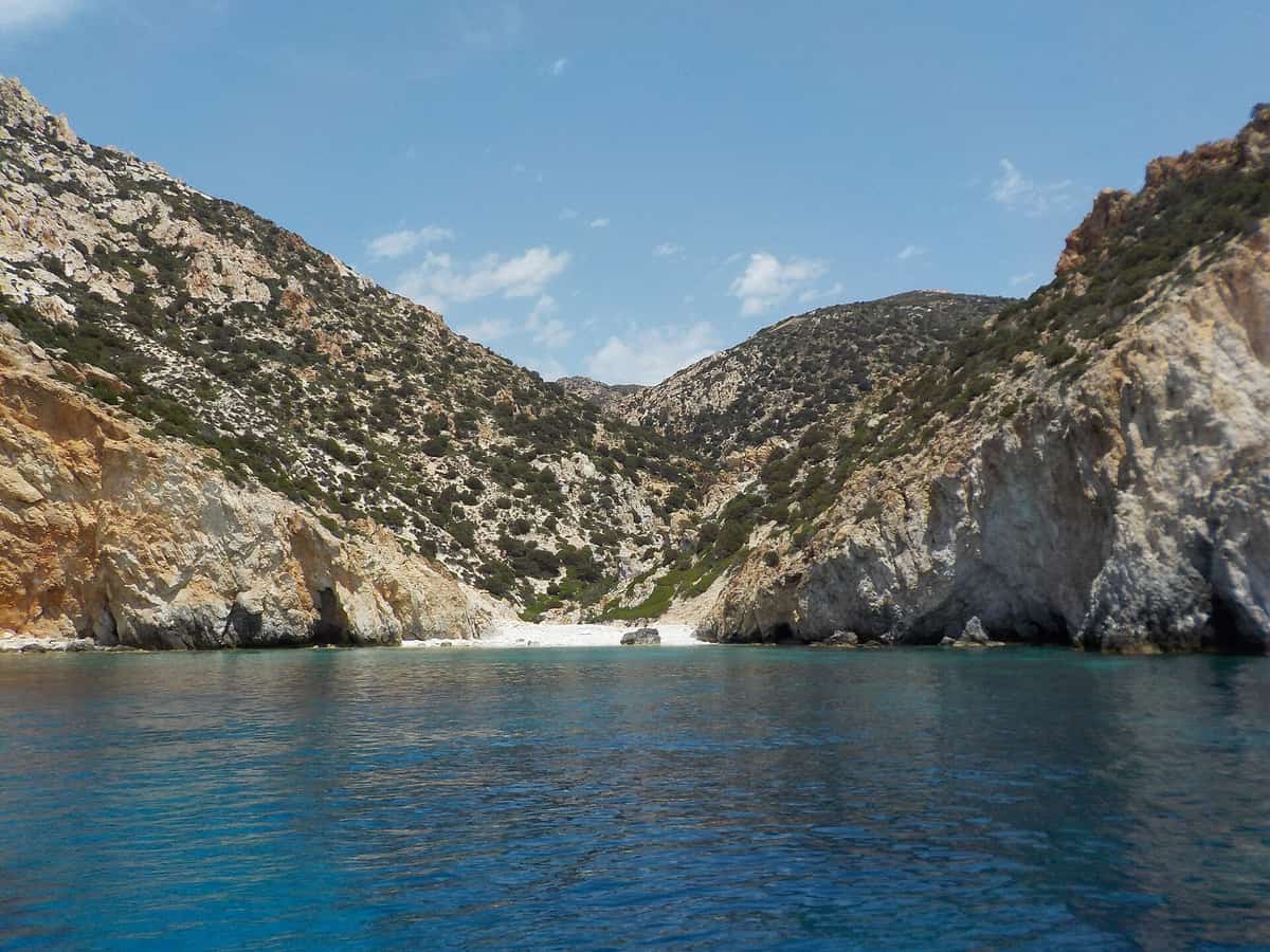 Μήλος Κίμωλος Πολύαιγος κρουαζιέρα: γαλαζοπράσινα νερά μπροστά σε όρμο της Πολυαίγου με ηφαιστειακούς βράχους