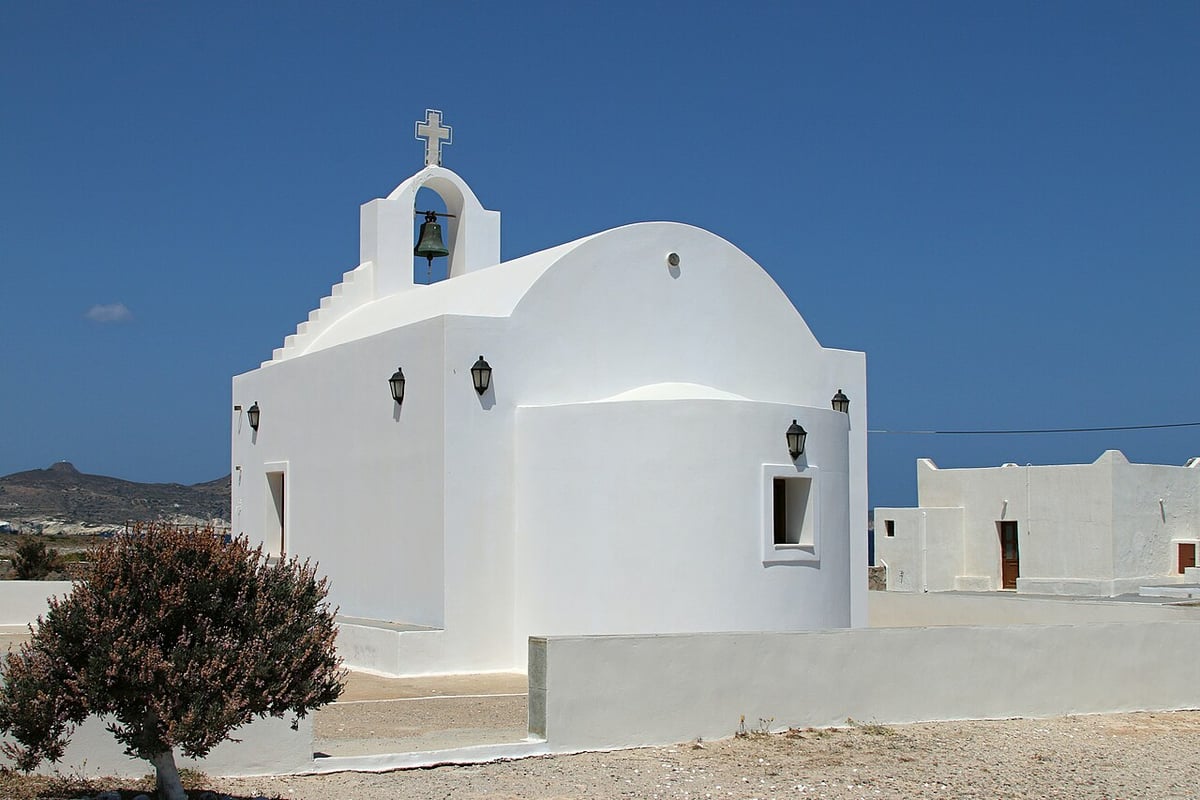 Πανηγύρια Μήλος: λευκό ξωκλήσι με καμπαναριό και σταυρό στον οικισμό Άγιος Κωνσταντίνος