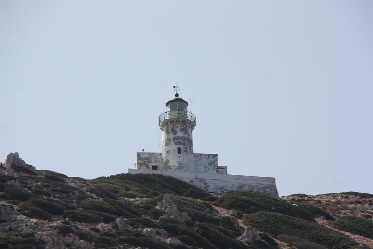 Πολύαιγος: ο πέτρινος φάρος του νησιού πάνω σε βραχώδη λόφο με χαμηλούς θάμνους